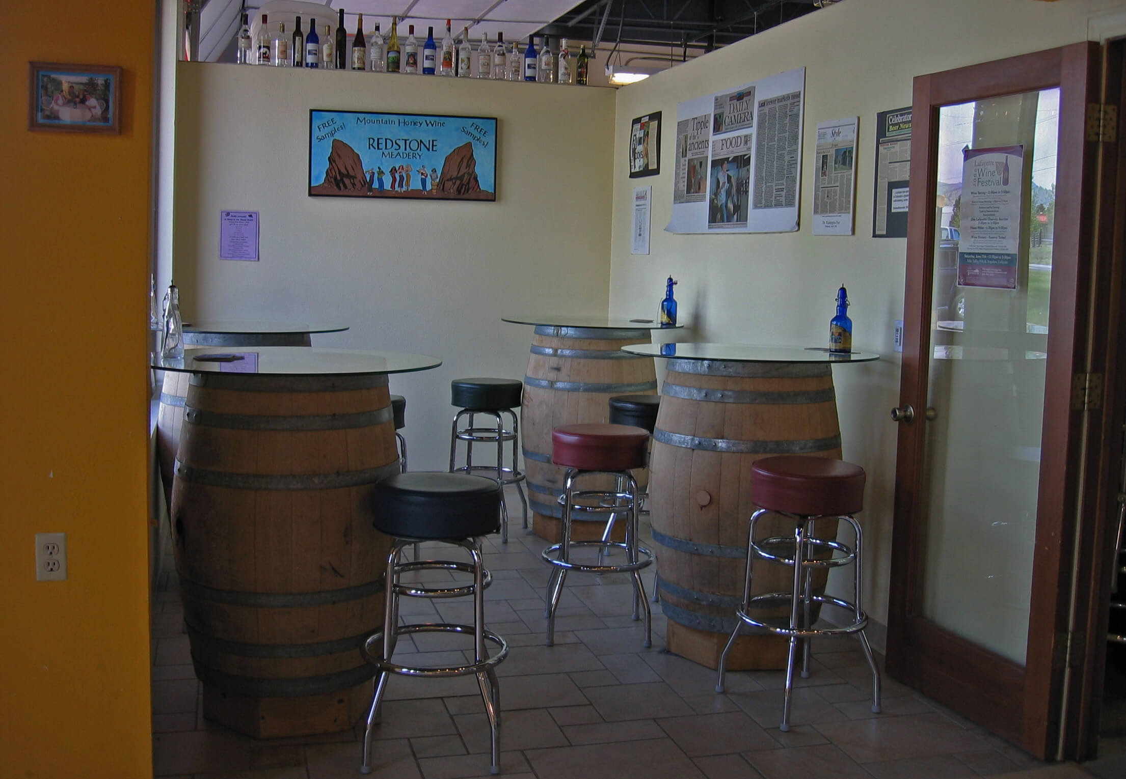 Tasting room with several tables, stools, and Redstone artwork